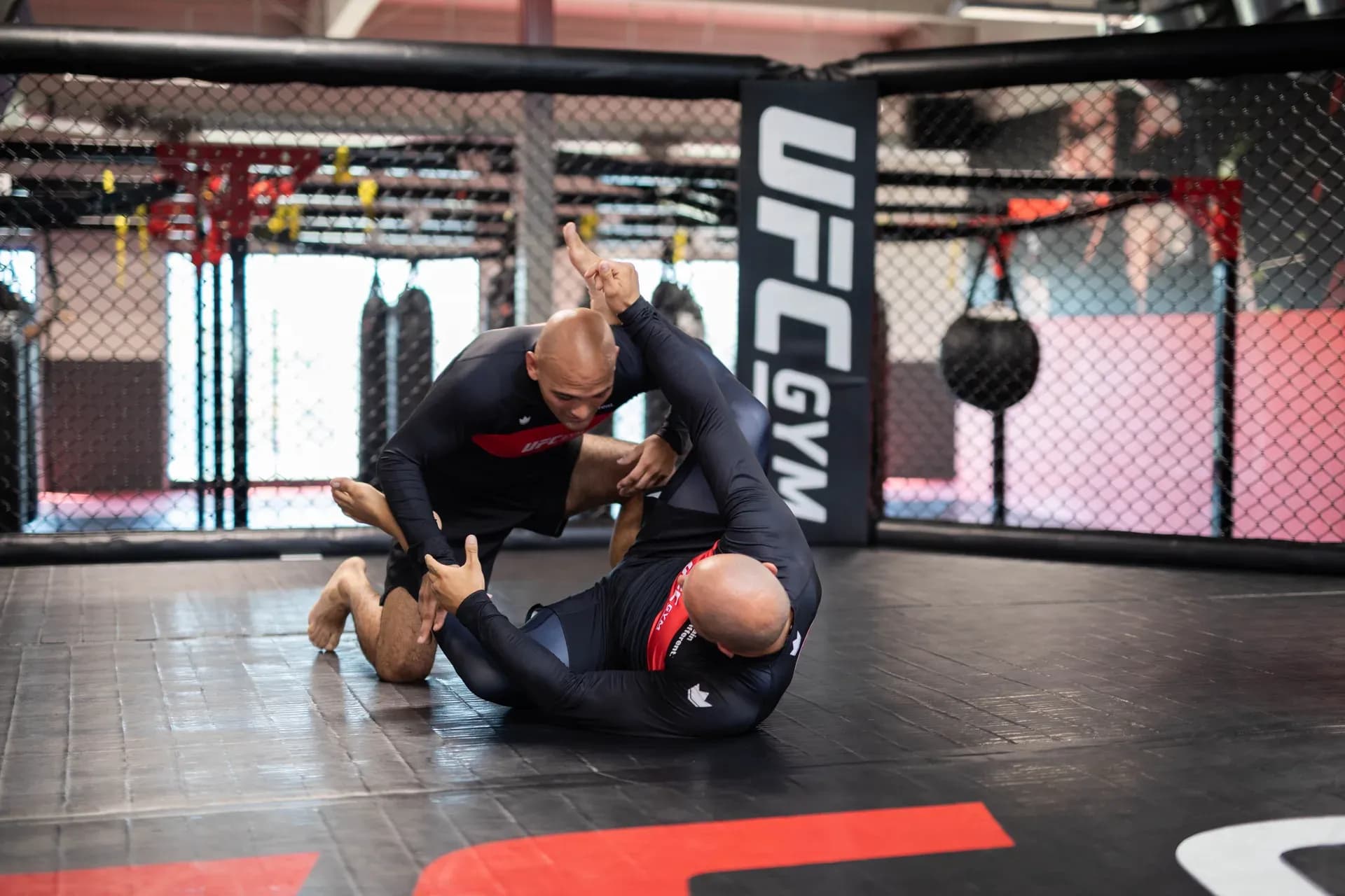 Entraînement au sol dans la cage d'un club UFC GYM